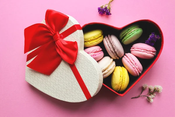 Pasteles macarrones franceses en forma de corazón caja de regalo sobre fondo rosa pastel. Un dulce regalo para el Día de San Valentín. Enfoque selectivo, vista superior, plano —  Fotos de Stock