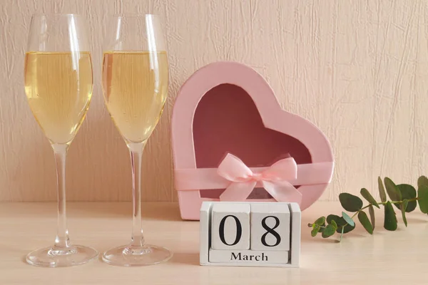 Calendario de madera 08 de marzo, una copa de champán y una caja de regalo en forma de corazón. Concepto del Día de la Mujer. Enfoque selectivo, primer plano —  Fotos de Stock