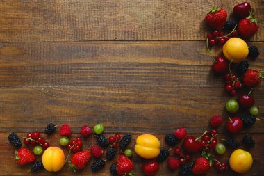 Ahşap arka planda taze meyve ve böğürtlen çerçevesi. Uzayı metin için kopyala. Düz yatış, düzen, üst manzara. Yaz konsepti.