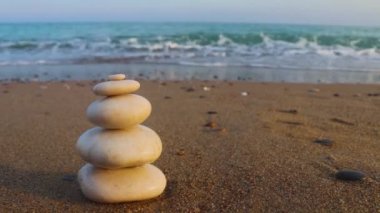 Zen taşları ve deniz dalgaları. Uyum, istikrar, yaşam dengesi, rahatlama ve meditasyon kavramı. Deniz kıyısında bir taş piramidi.
