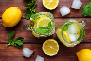 Limonlu taze limonlu limonata, ahşap bir masada nane ve buz. Yaz ferahlatıcı içecekler. Yakın plan, seçici odaklanma. Üst görünüm.