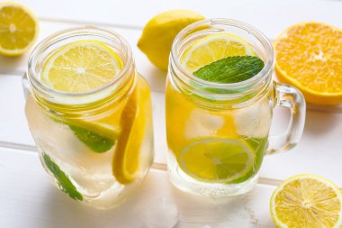 Limonlu, portakallı, naneli ve buzlu taze limonlu limonata. Yaz ferahlatıcı içecekler. Yakın çekim, seçici odaklanma.