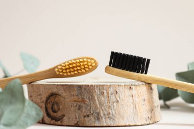 Bir çift çevre dostu bambu diş fırçası yakın plan kesilmiş bir tahta üzerinde. Ağız temizliği ve sıfır atık konsepti. Seçici odak