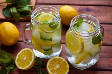 Limonlu limonlu taze narenciye, tahta bir masada kavanozlarda nane ve buz. Yaz ferahlatıcı içecekler. Yakın çekim, seçici odaklanma