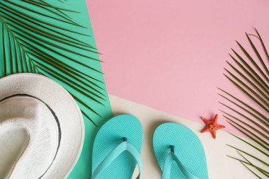 Yaz tatili geçmişi. Palmiye yaprakları, yaz şapkası, parmak arası terlikler ve kabuklu pembe, yeşil ve bej desenli fotokopi alanı. Üst manzara, düz uzanma