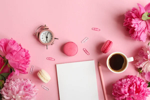メモ帳 目覚まし時計 牡丹の花 ピンクの背景にコーヒーとマカロンのカップを持つ女性の職場 ビジネス フリーランス 教育の概念 トップビュー フラットレイアウト — ストック写真