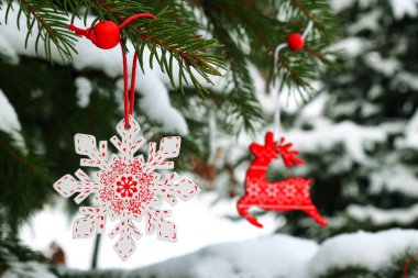 Karla kaplı bir ladin dalında Noel süsleri kar tanesi ve geyik. Noel ve Yeni Yıl konsepti. Seçici odak