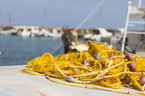 Redes de pesca e barcos de pesca gregos atracando no porto ao nascer do sol — Fotografia de Stock