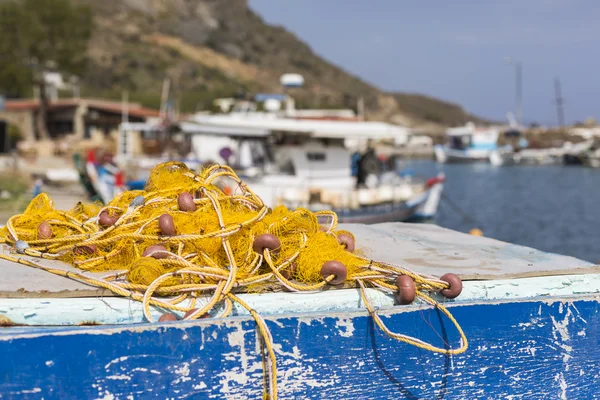 Fischernetze und griechische Fischerboote, die bei Sonnenaufgang im Hafen festmachen — Stockfoto