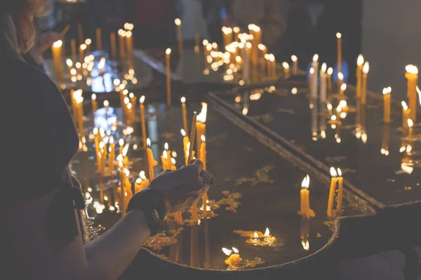 Candele accese in una chiesa su uno sfondo scuro — Foto Stock