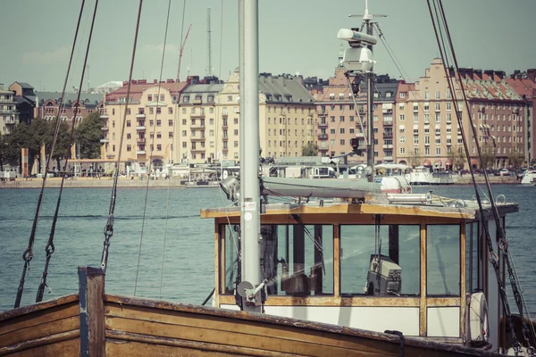 Old city buildings and old boats on water under blue sky in Stoc — Stock Photo, Image