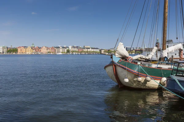 Old city buildings and old boats on water under blue sky in Stoc — Stock Photo, Image