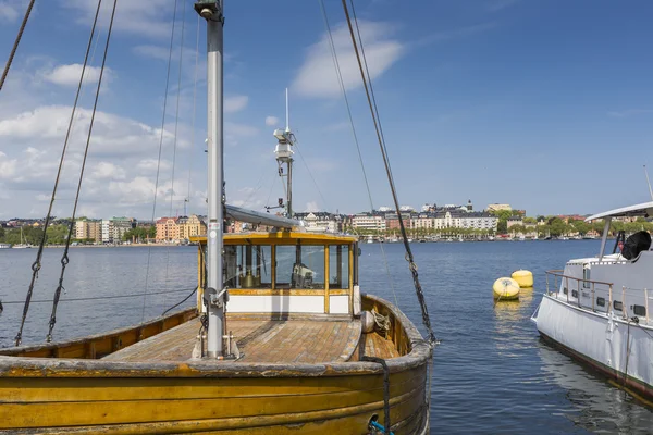 Old city buildings and old boats on water under blue sky in Stoc — Stock Photo, Image