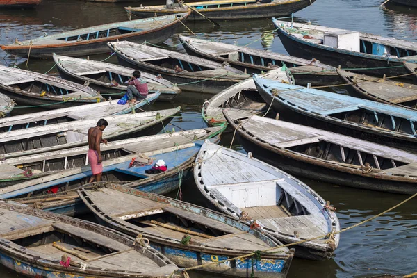 VARANASI, INDIA - 26 DE ENERO DE 2012: Barcos antiguos en aguas marrones de — Foto de Stock