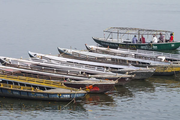 VARANASI, INDE - 26 JANVIER 2012 : Vieux bateaux sur les eaux brunes de — Photo