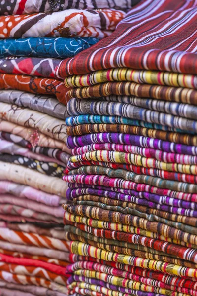 Colorful fabrics and carpets for sale on a street in Medina of E — Stock Photo, Image