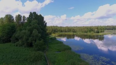 Yaz saati göl ve yeşil orman, beyaz bulutlar üzerinde Polonya peyzaj mavi gökyüzünde.
