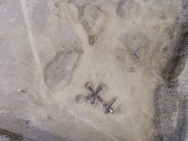 Flygfoto över grävmaskin och lastbil arbetar på fältet av sand — Stockfoto