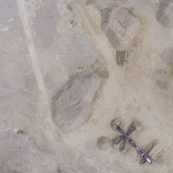 Flygfoto över grävmaskin och lastbil arbetar på fältet av sand — Stockfoto