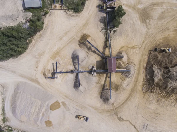 Vista aérea da escavadeira e caminhão trabalhando no campo de areia — Fotografia de Stock