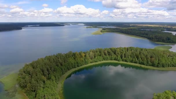 Masuria ve Podlasie bölgesinde, Polonya göl kenarında küçük adalar manzarası. Mavi su ve beyaz bulutlar. Yaz saati. Yukarıdan görüntülemek. — Stok video