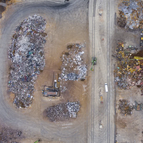 Iron raw materials recycling pile, work machines. Metal waste ju Royalty Free Stock Photos