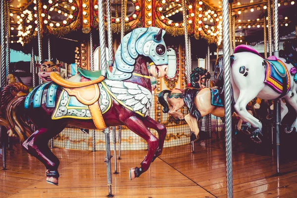 Old French carousel in a holiday park. Three horses and airplane on a traditional fairground vintage carousel. Merry-go-round with horses. — Stock Photo, Image