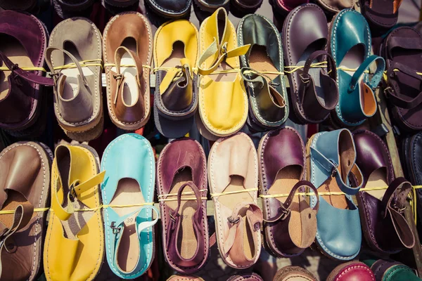 Leather shoes in different colors at a flea market — Stock Photo, Image