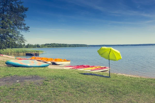 Colorful kayaks moored on lakeshore, Goldopiwo Lake, Mazury, Pol — Stock Photo, Image