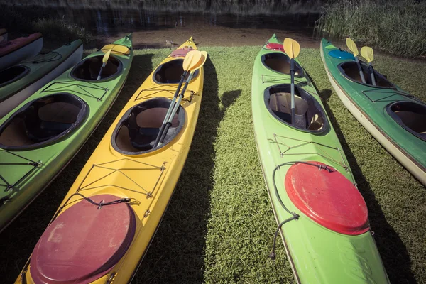 Coloridos kayaks amarrados en la orilla del lago — Foto de Stock