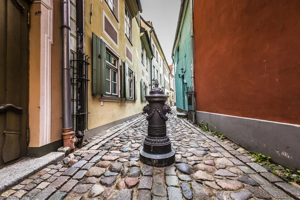 Decorative water column in narrow medieval street of old Riga ci — Zdjęcie stockowe