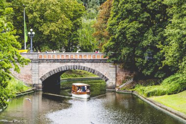 Park ve turist tekne yelken ağaçların arasından güneş ışığı