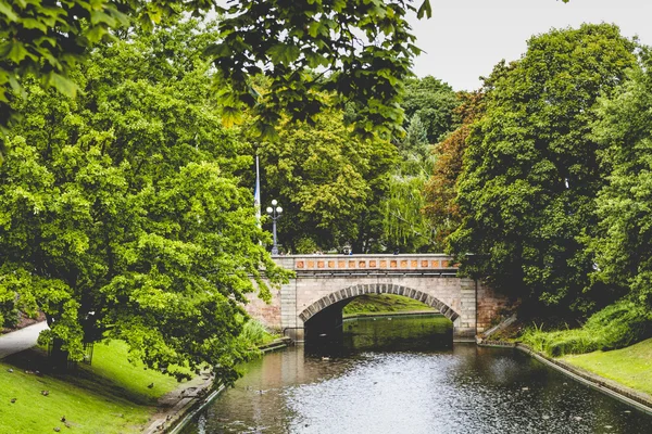 Park ve turist tekne yelken ağaçların arasından güneş ışığı — Stok fotoğraf