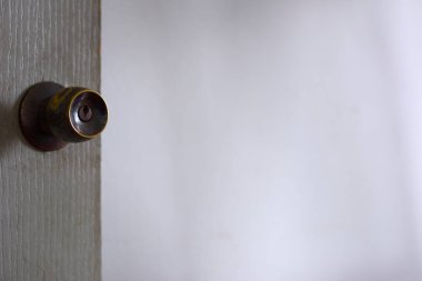 Doğal beyaz arka planda soyut kahverengi düğme ve gri ahşap kapı.