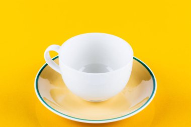 Empty white coffee cup isolated on yellow background.