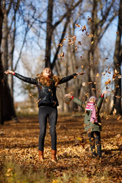 Ung mamma och hennes tjej i höst park — Stockfoto