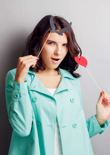 Funny woman with horns holding a heart. — Stock Photo, Image