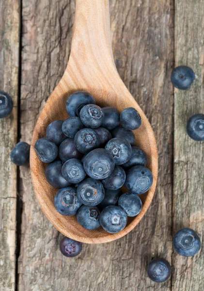 Fresh blueberries in a wooden spoon over wooden table — Stock Photo, Image