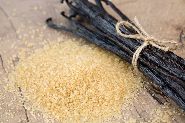 Vanilla pods and brown cane sugar — Stock Photo, Image