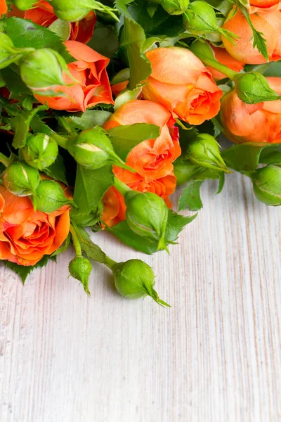 Rosas naranjas sobre superficie de madera — Foto de Stock