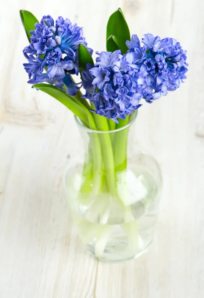 木の表面にガラスの花瓶で青いヒヤシンス — ストック写真