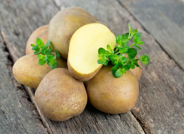 Patate nuove su una superficie di legno — Foto Stock