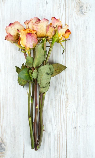 Dried roses on wooden surface — Stock Photo, Image