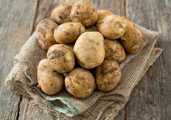 Potatoes on wooden surface — Stock Photo, Image