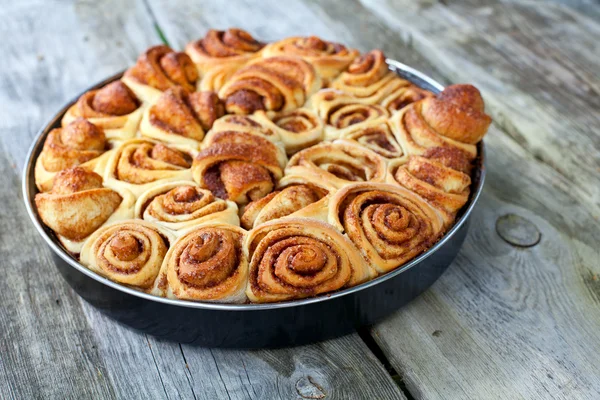 Cinnamon buns on wooden surface — Stock Photo, Image