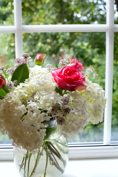 Schöner Blumenstrauß auf der Fensterbank — Stockfoto