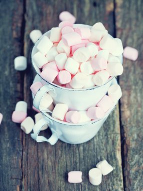 Marshmallow ahşap masa üzerinde metal bardak