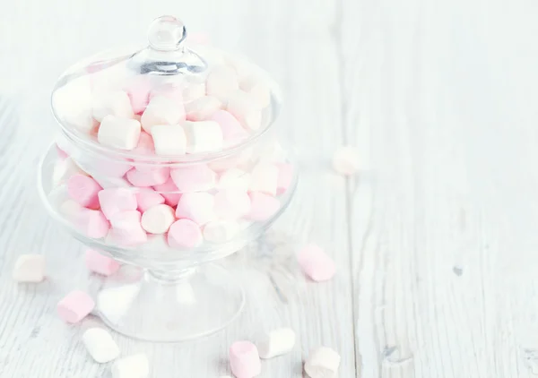 Marshmallows w pięknym szklanym naczyniu na drewnianym stole — Zdjęcie stockowe