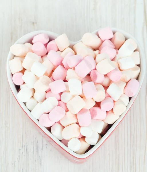Marshmallows w sercu kształt miski na drewnianym stole — Zdjęcie stockowe