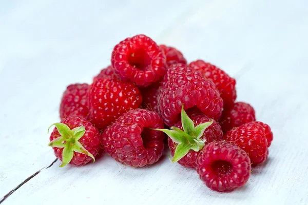 Heap of fresh raspberries on wooden surface — Stock Photo, Image